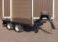 Tandem axle skip trailer with spare wheel on towing frame.